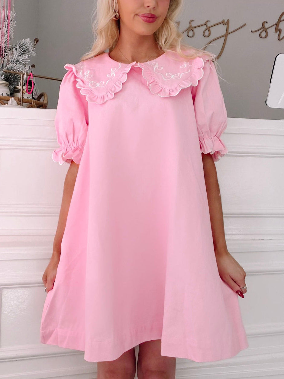 Denim Doll Pink Dress from Sassy Shortcake - Woman wearing a pink dress with lace details in a room setting.