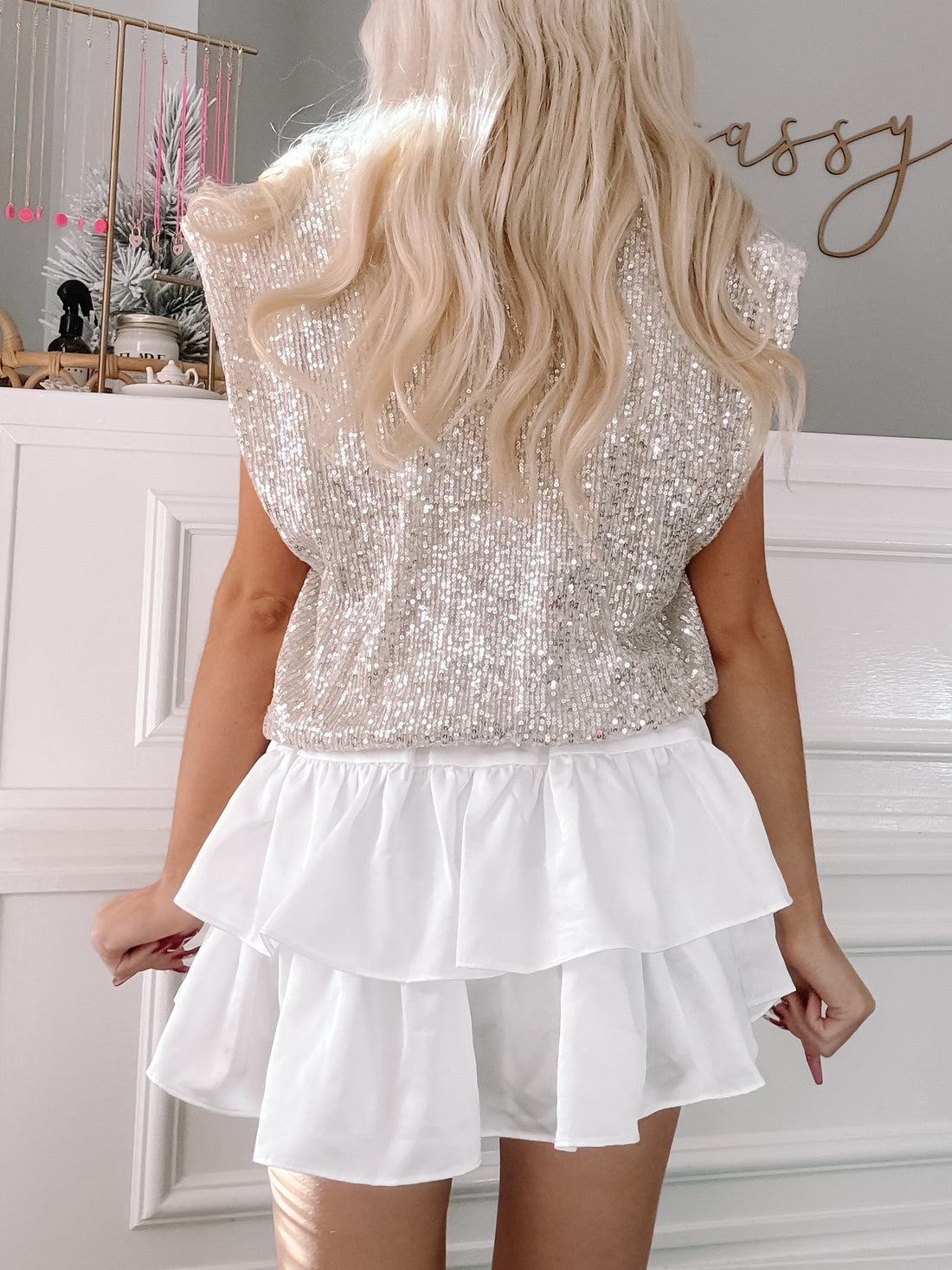 Champagne sequin top paired with a white tiered ruffle skirt, shown from the back.
