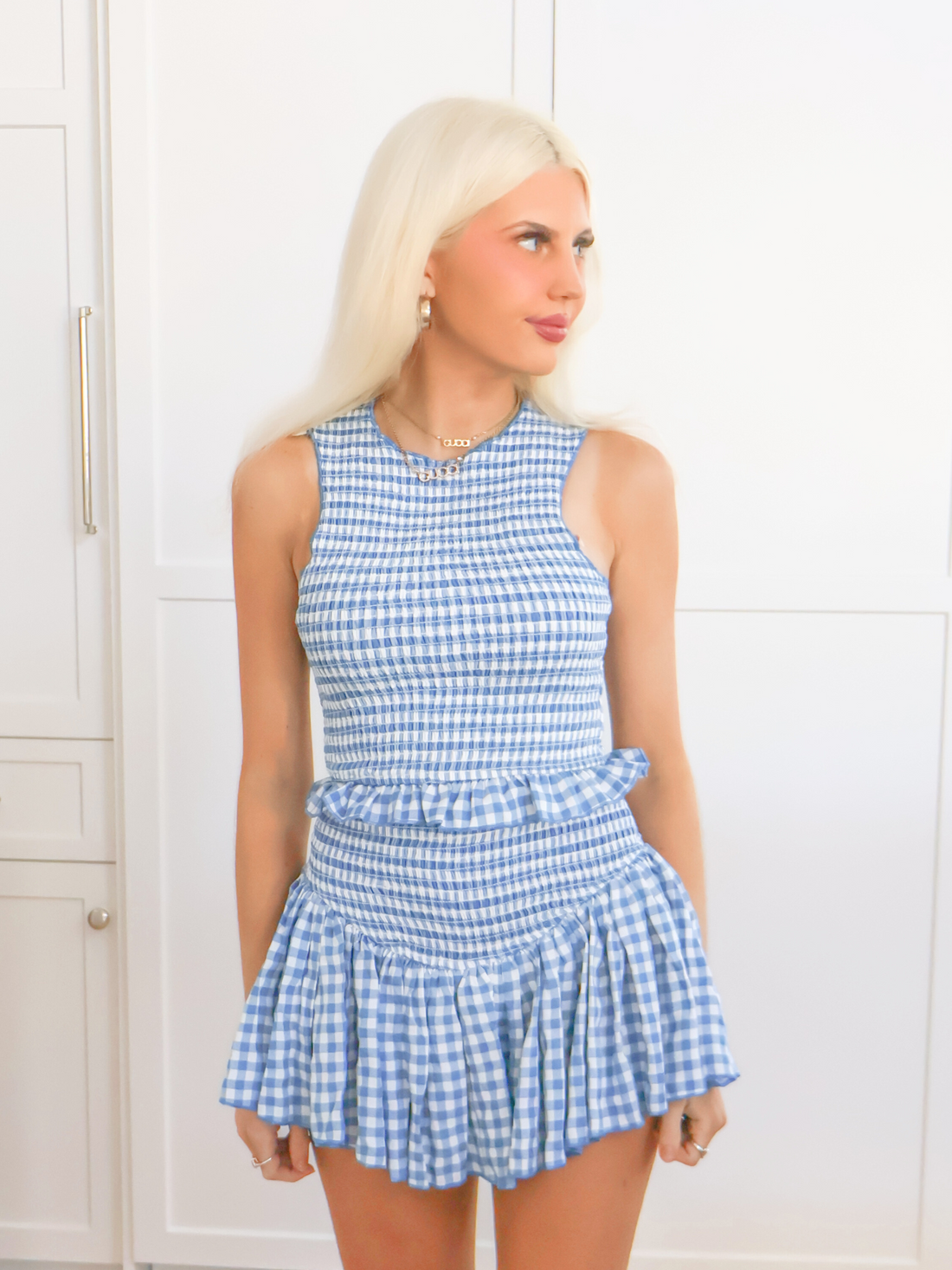 Model wearing the blue gingham Dorothy Set with a smocked crop top and ruffle mini skirt from Sassy Shortcake