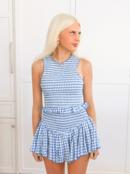 Model wearing the blue gingham Dorothy Set with a smocked crop top and ruffle mini skirt from Sassy Shortcake