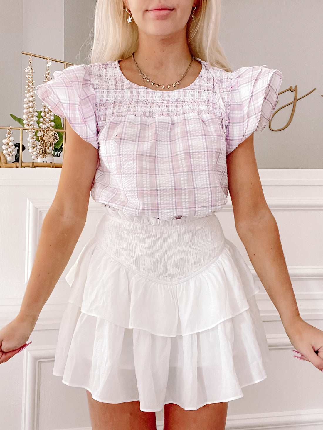 Lavender plaid peasant top styled with a white tiered mini skirt.
