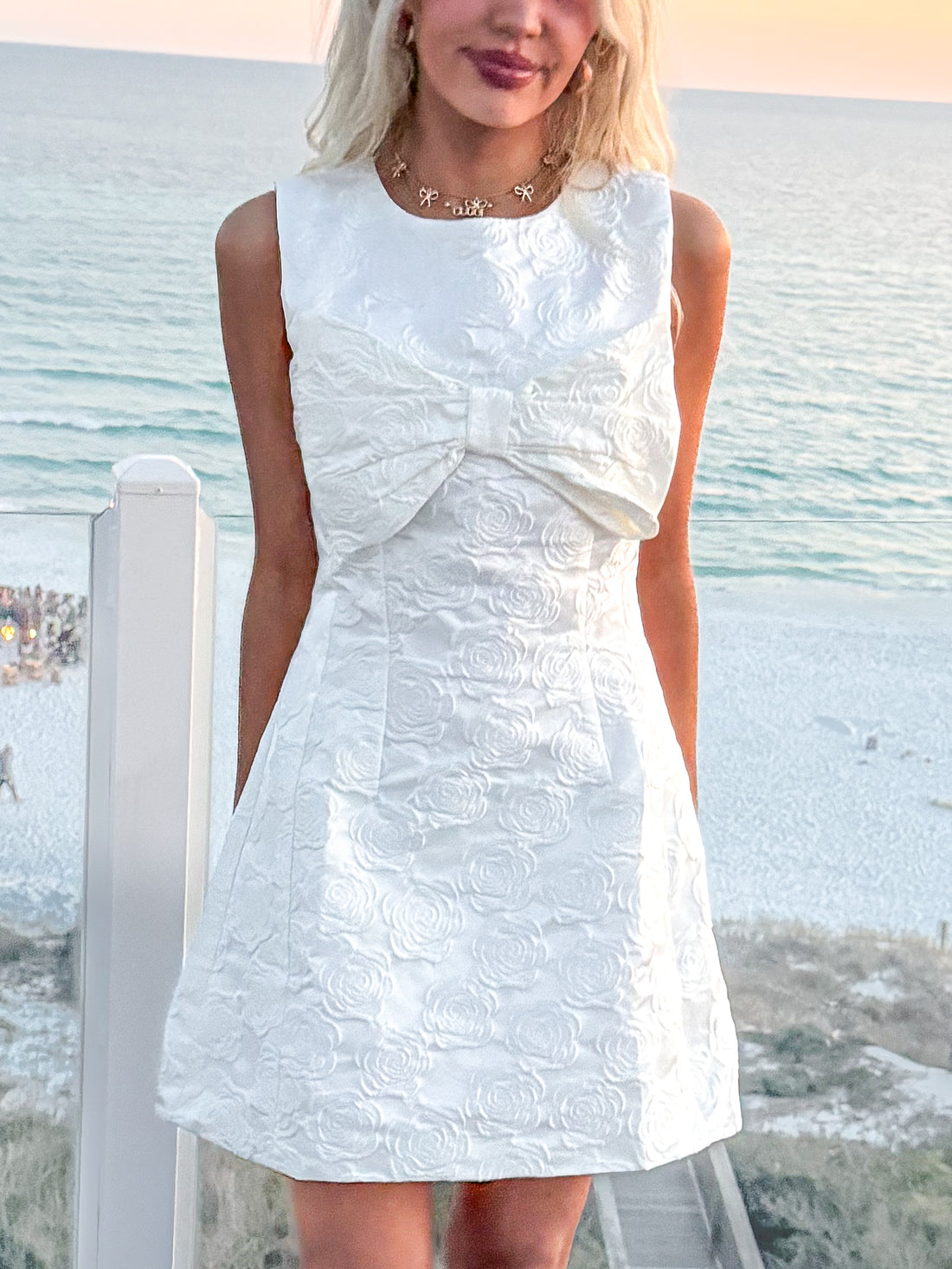 White rose-embossed Everlasting Bow dress, sleeveless, fit-and-flare silhouette.

