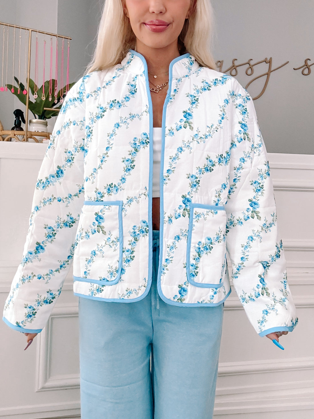 Blue floral quilted jacket, light blue trim, and front pockets.
