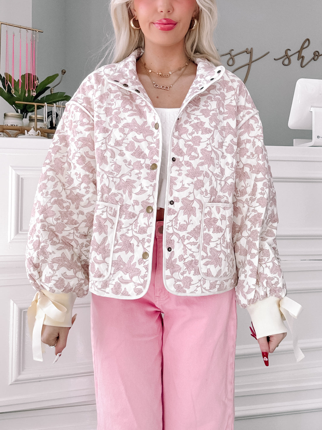 Floral Daydream quilted jacket in blush pink floral print with button front and ribbon-tied cuffs.
