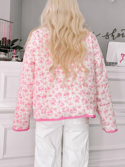 Floral Quilted Pullover from Sassy Shortcake - Person wearing a pink floral blouse with white pants in an indoor setting.