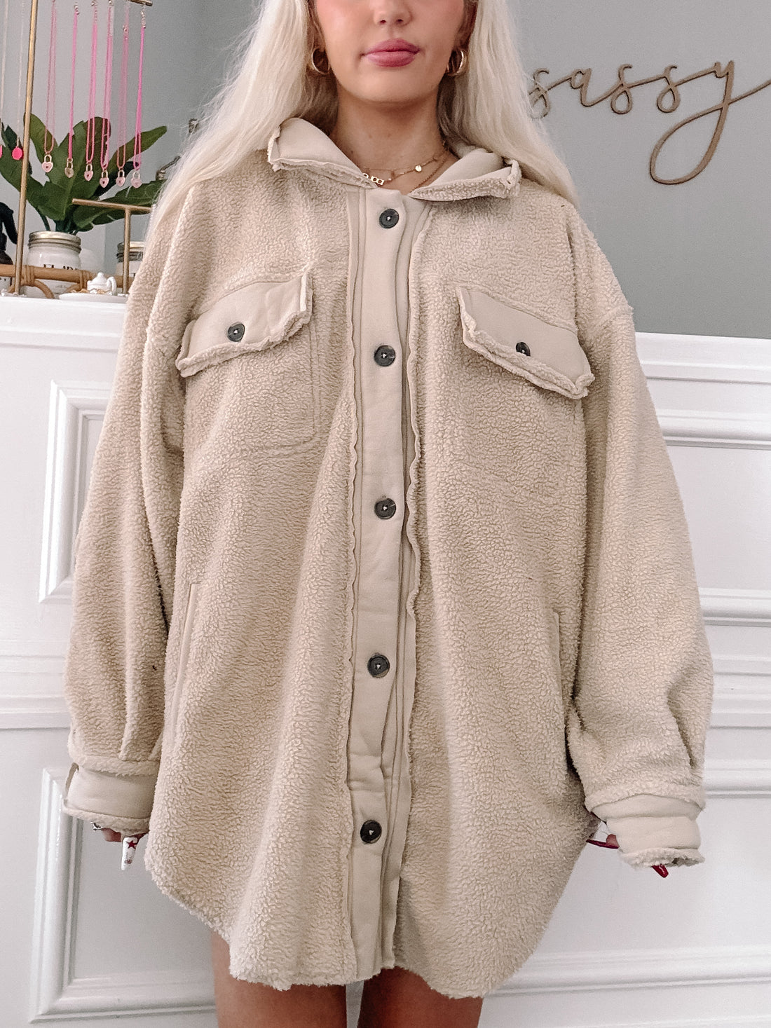Cream-colored fuzzy shacket, button-front, oversized fit, modeled against a white wall.
