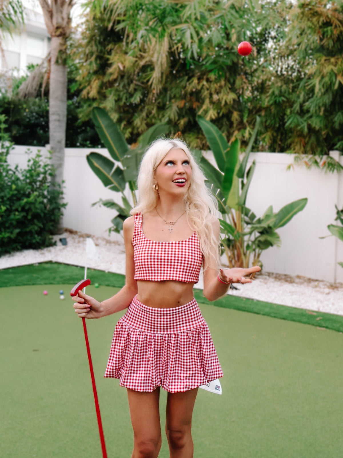 Game for Gingham Bubble Skirt by Sassy Shortcake  - Woman in a red and white gingham outfit on a putting green.