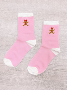 Pink gingerbread socks with white trim, featuring adorable gingerbread person design.
