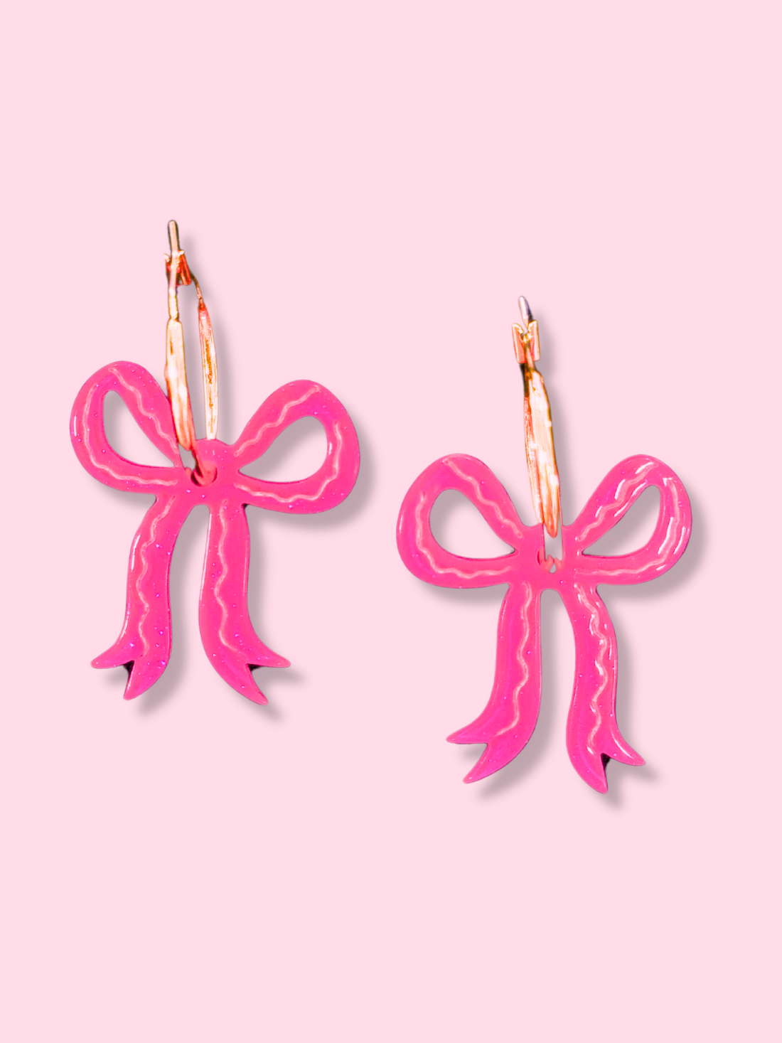 Pink Glitter Bow Hoops:  Sparkly pink resin bow earrings on gold hoops.
