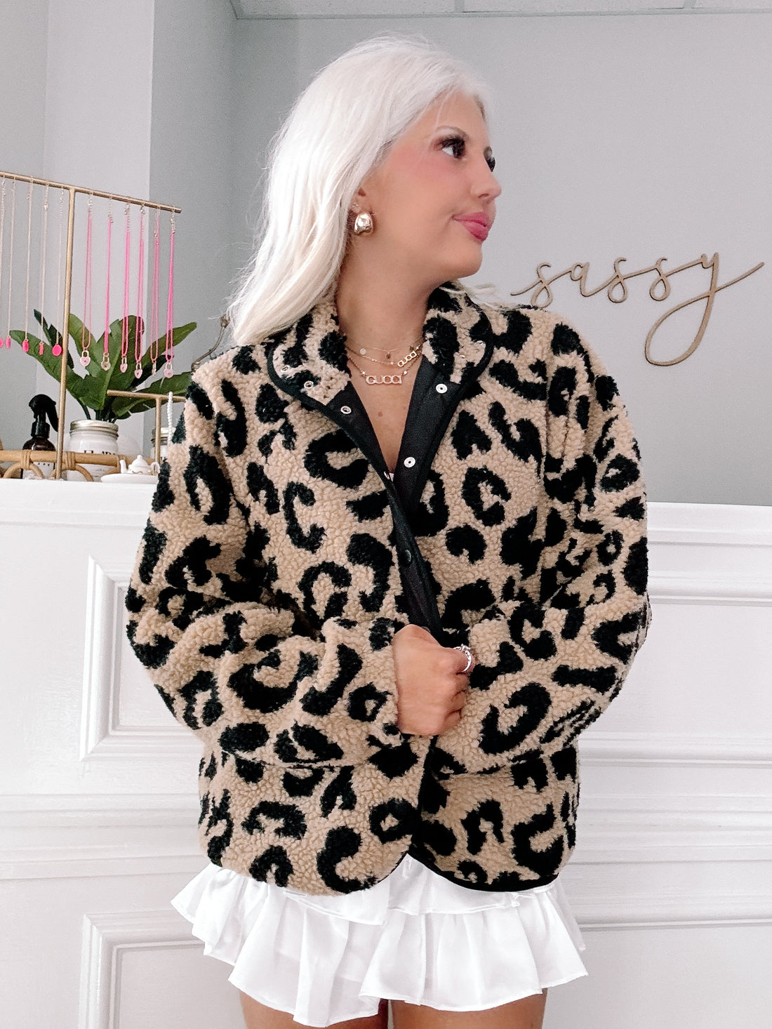 Tan leopard-print sherpa jacket, button front, modeled against a white wall.
