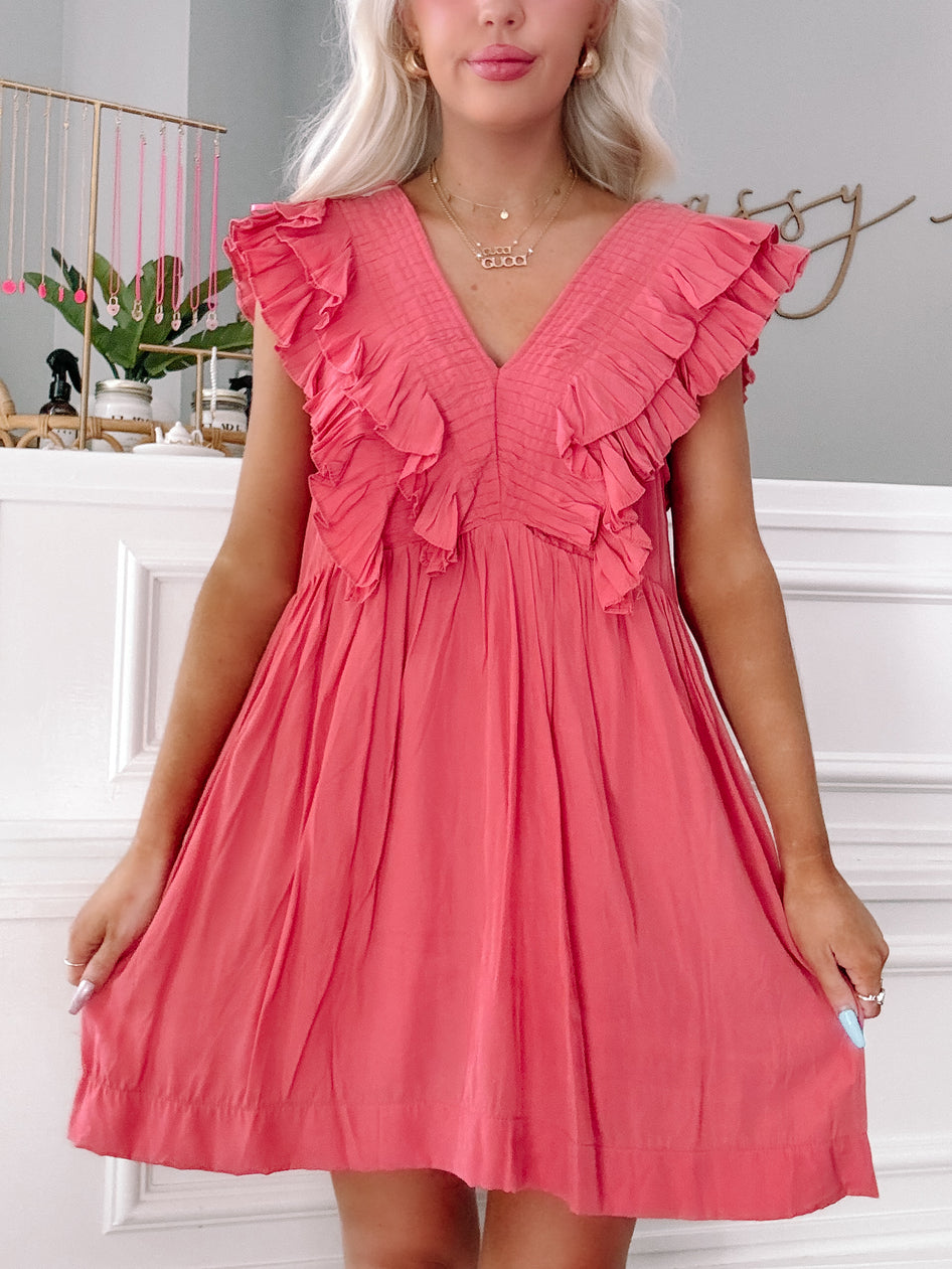 Coral pink mini dress with ruffled sleeves, pleated bodice, and V-neckline.
