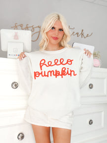 model wearing a white sweatshirt with Hello Pumpkin written in orange on the front from Sassy Shortcake