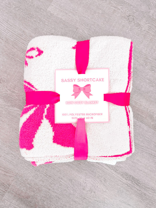 Hot pink bow patterned microfiber blanket, 50x60 inches, tied with a ribbon.
