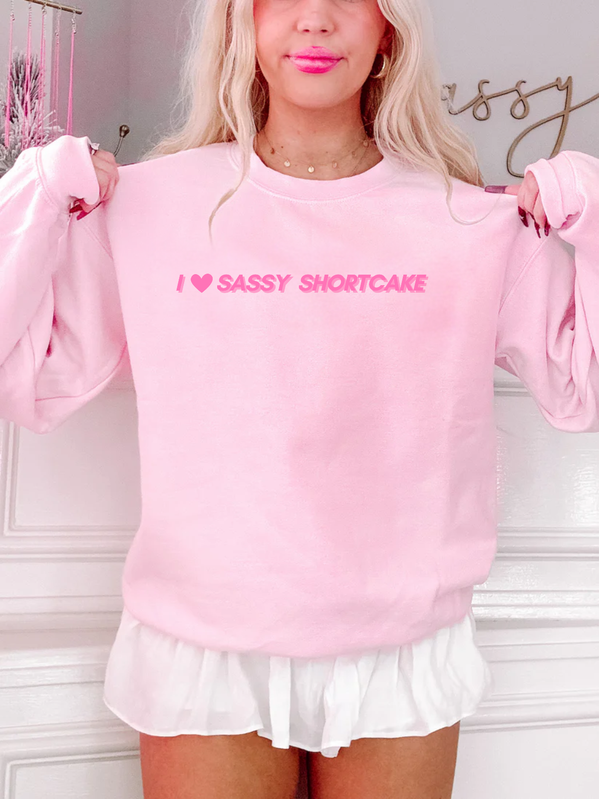 Model wearing light pink crewneck with I heart Sassy Shortcake text. Sassy Shortcake Merch 