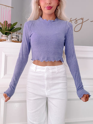 Periwinkle blue ribbed long-sleeve crop top with scalloped hem.
