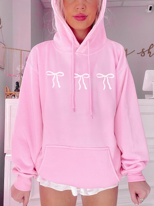 Pink Blushing Bow Hoodie with three white bow accents.
