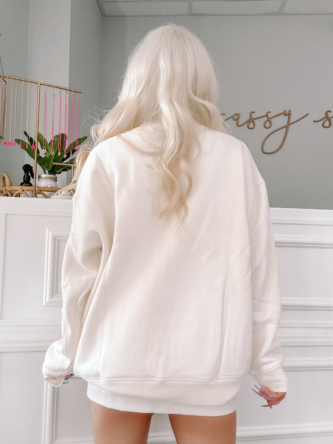 Cream-colored crewneck sweatshirt shown from the back, showcasing its soft fabric and relaxed fit.
