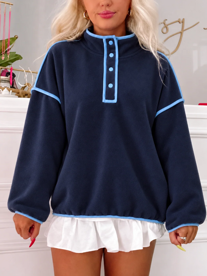 Model wearing the Ivy League Pullover from Sassy Shortcake, a navy fleece snap pullover with light blue piping, styled with a white ruffle skirt.
