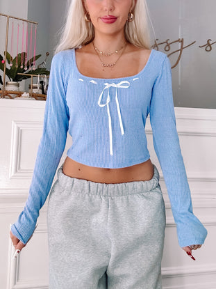 Jane Bow Top in light blue, ribbed knit fabric with white ribbon tie detail.
