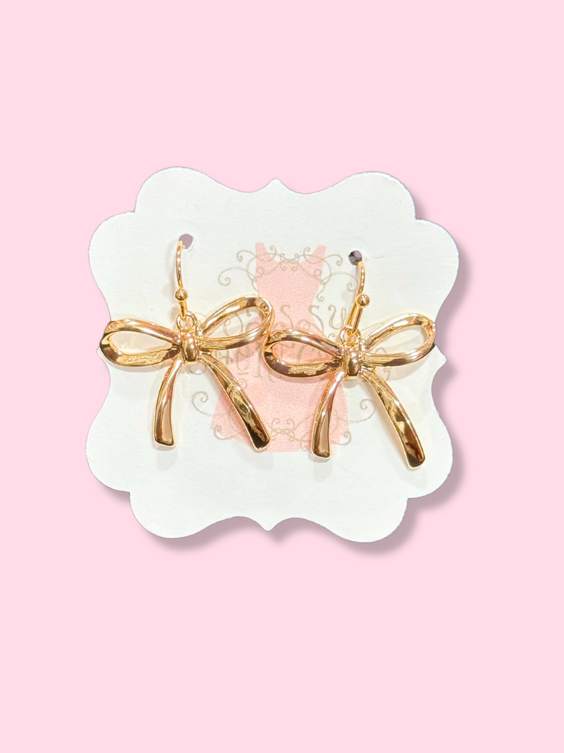 Gold Jordyn bow earrings on pink background

