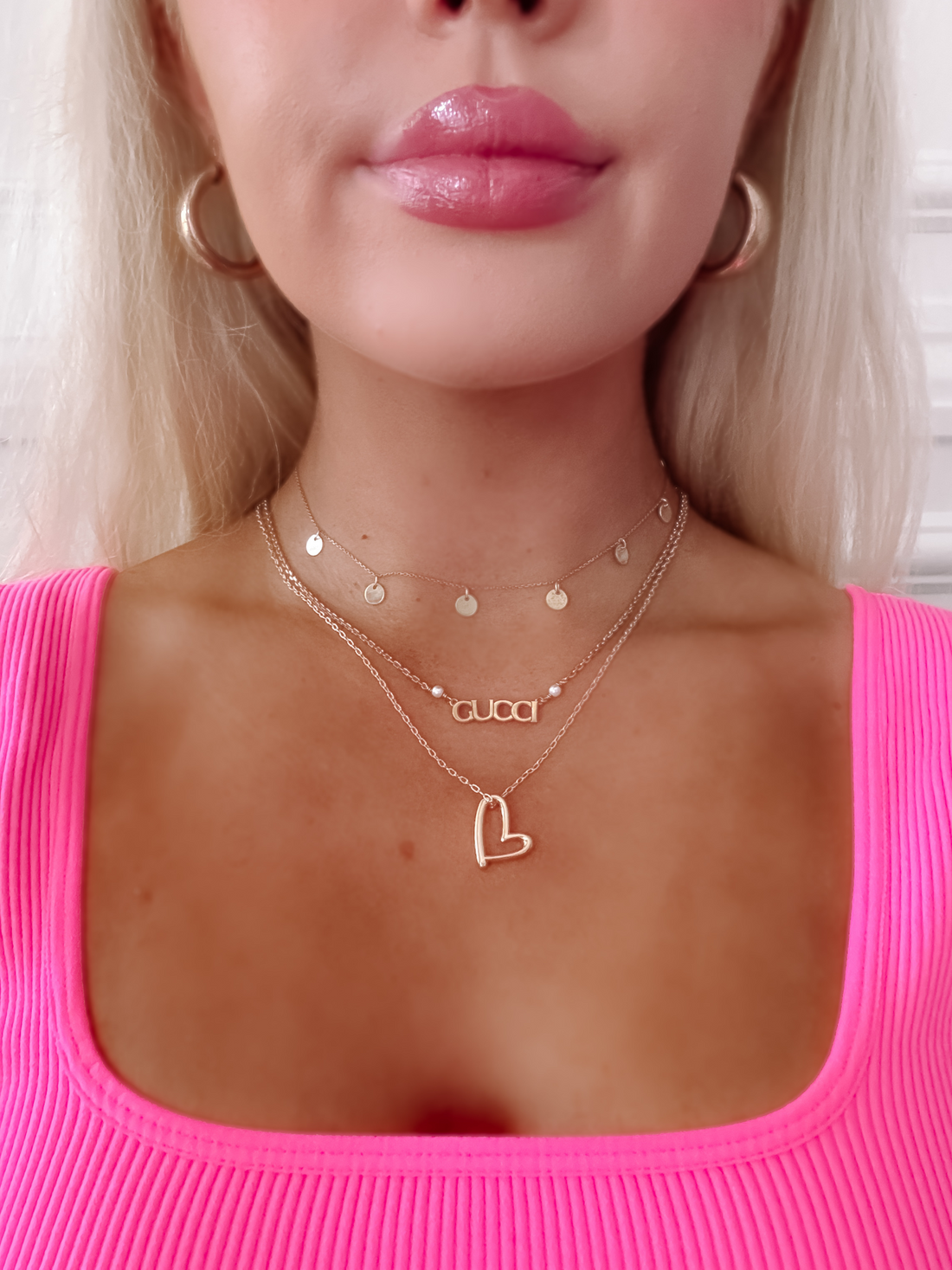Gold Lena Heart necklace layered with delicate chains & Gucci pendant.

