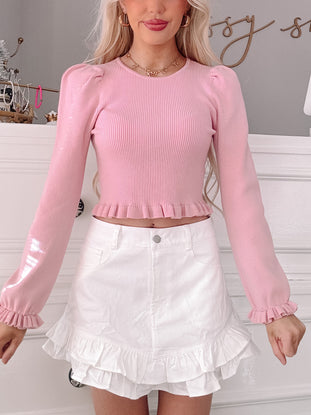 Pink ribbed Lenore long-sleeve crop top with ruffle trim.
