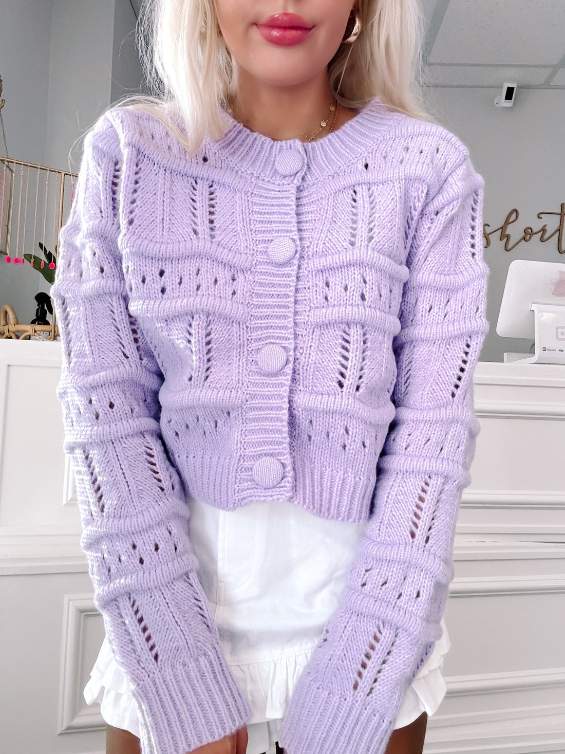 Lavender button-front cropped cardigan sweater with delicate knit detailing, shown on model.
