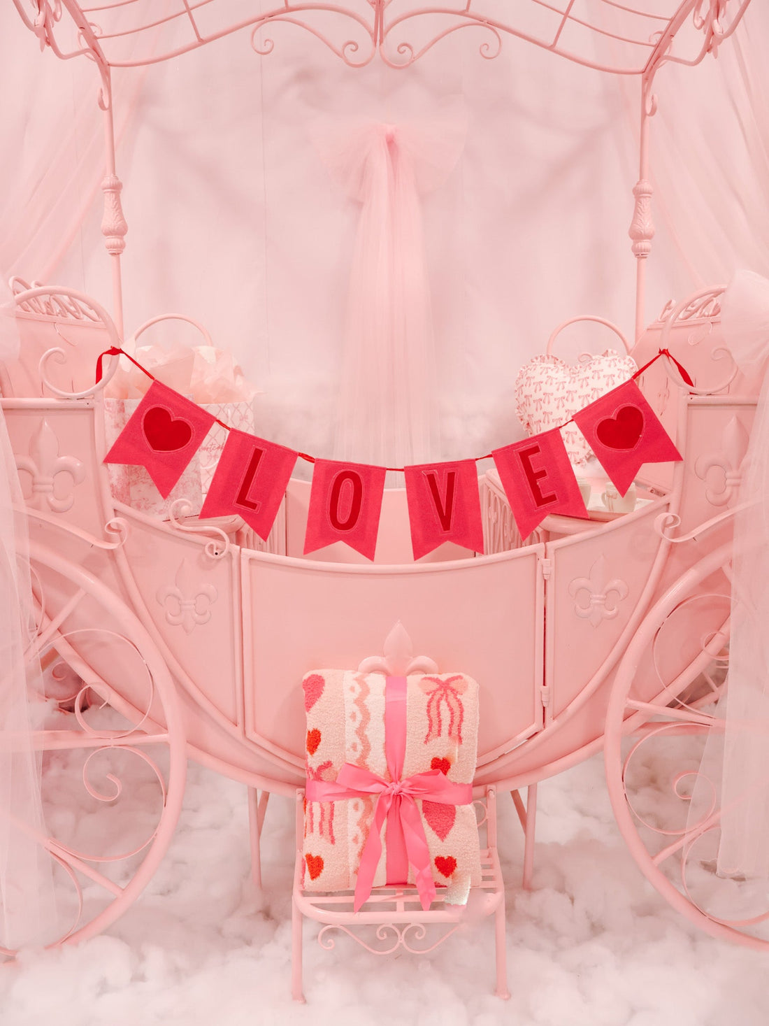 Love Bow Blanket Sassy Shortcake – cozy pink throw blanket styled on pink carriage under Valentine banner in boutique