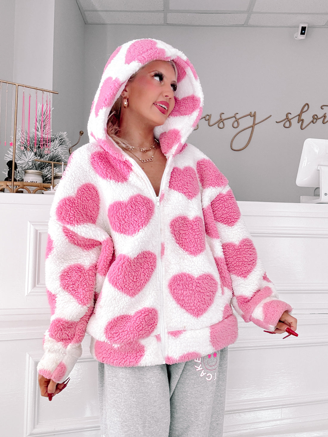 Pink and white heart-print sherpa jacket, cozy hooded style.
