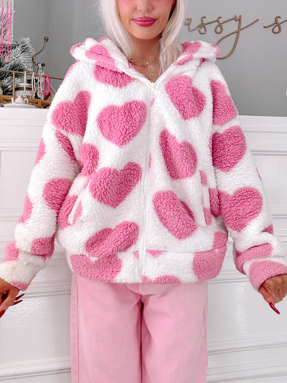 Pink & white sherpa Love Bug Jacket; cozy hooded zip-up with heart pattern.

