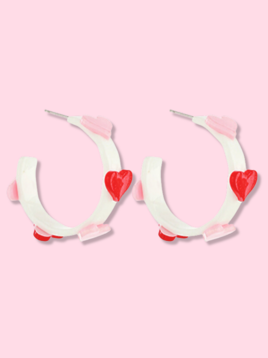White hoop earrings with pink and red heart accents.
