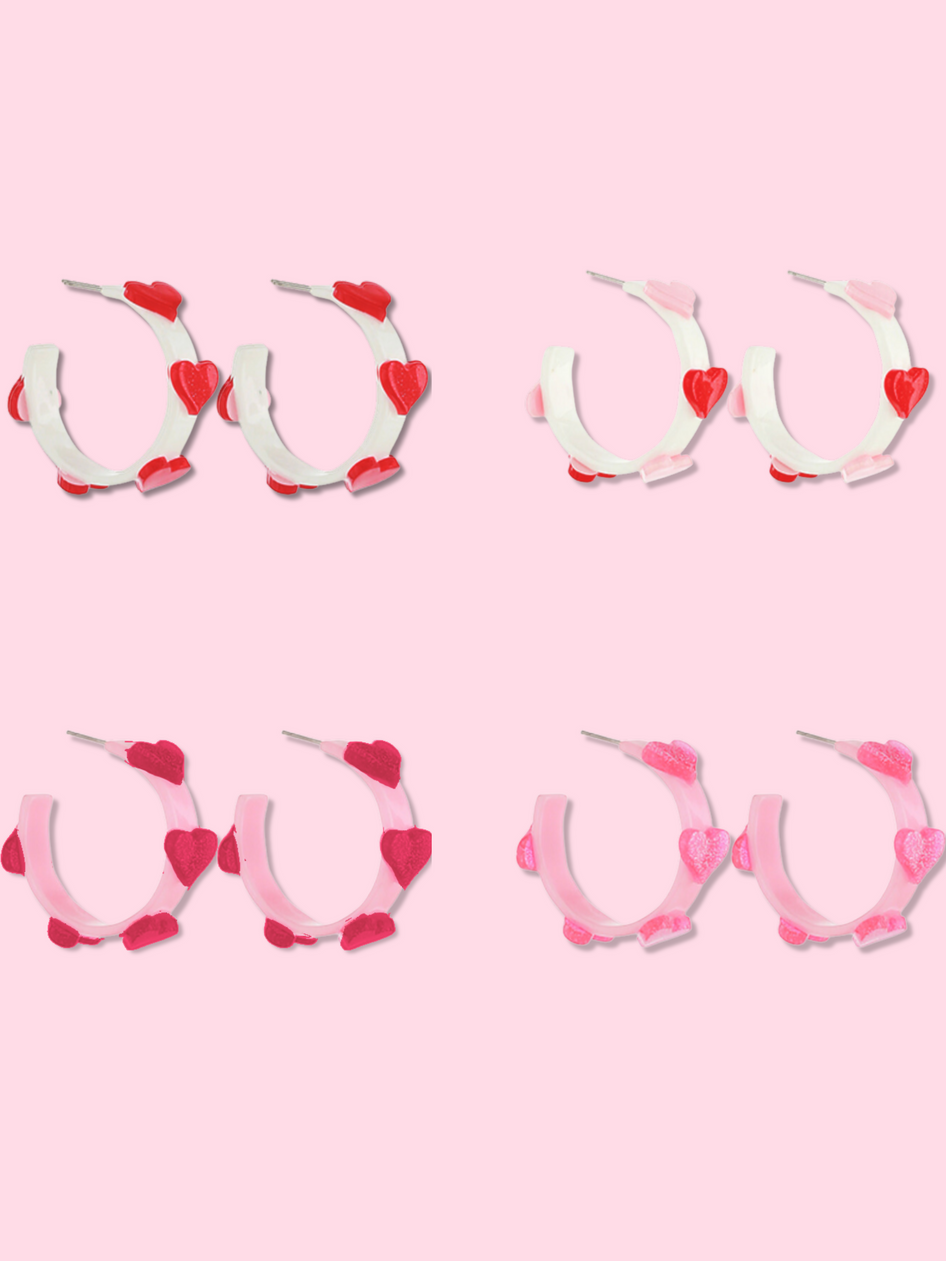 Pink and white heart-shaped hoop earrings; various styles.
