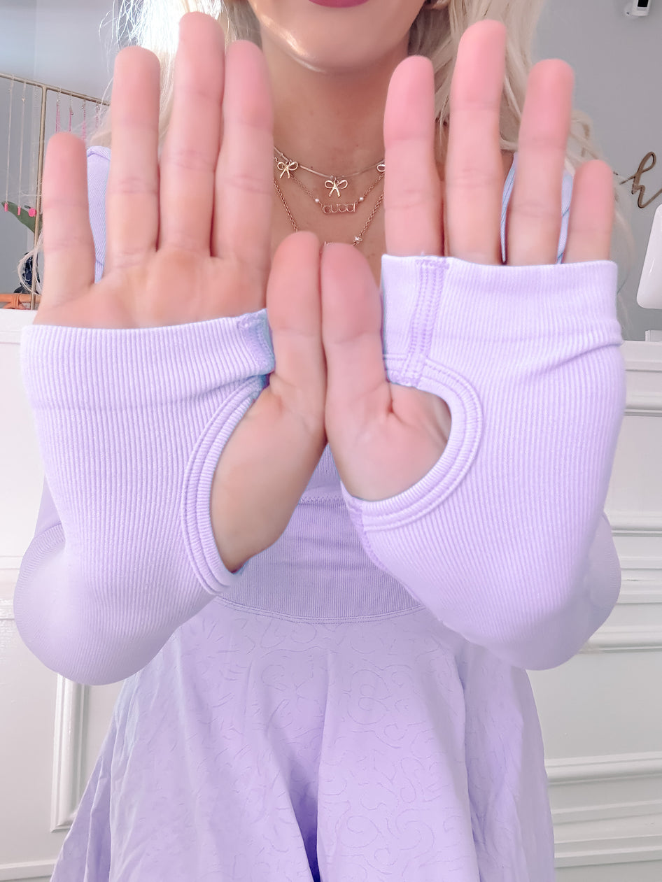 Close-up of lavender ribbed knit dress with thumbholes, showcasing textured fabric.
