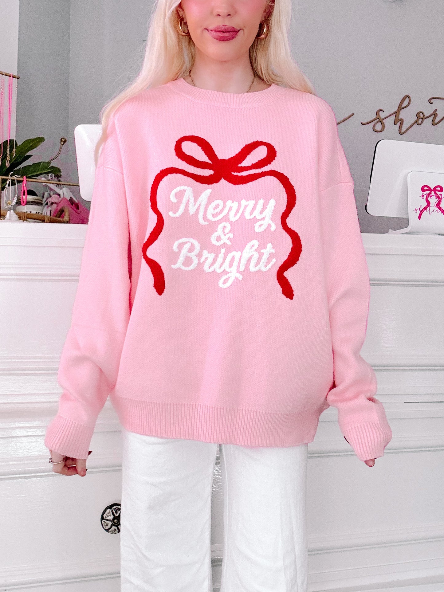 Person wearing a pink sweater with a red bow and 'Merry & Bright'  from sassy shortcake