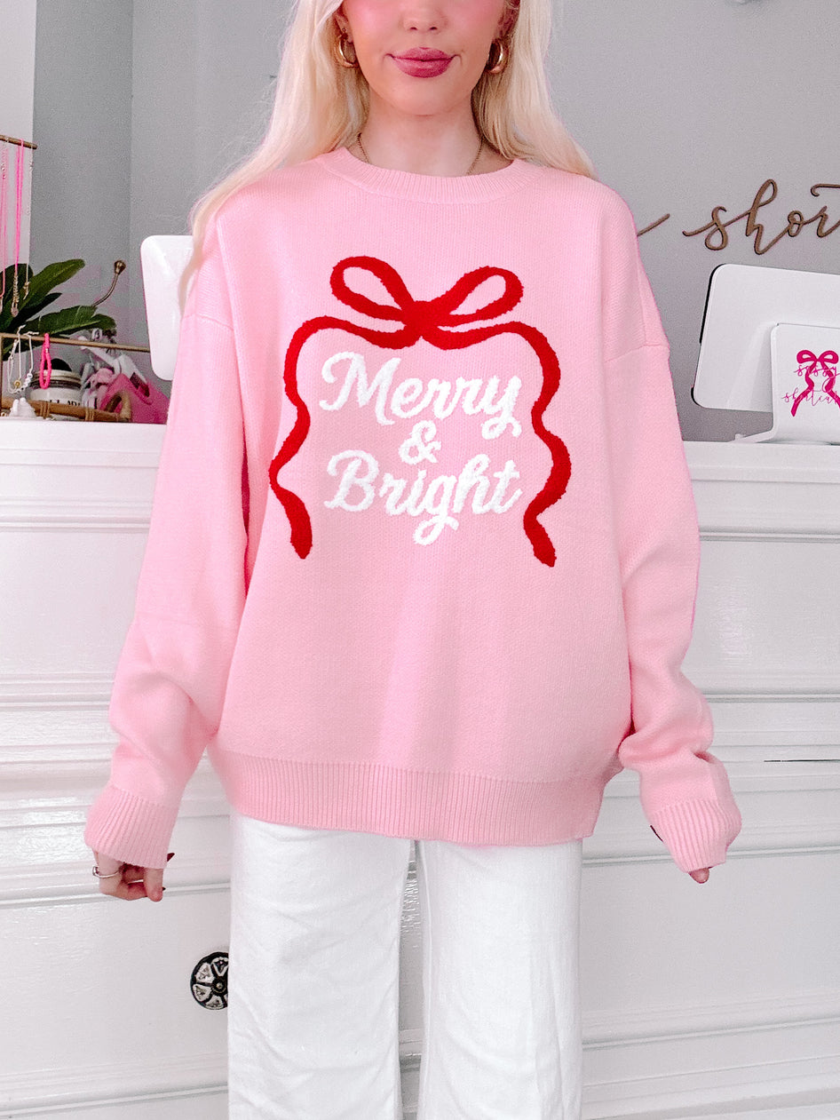 Person wearing a pink sweater with a red bow and 'Merry & Bright'  from sassy shortcake