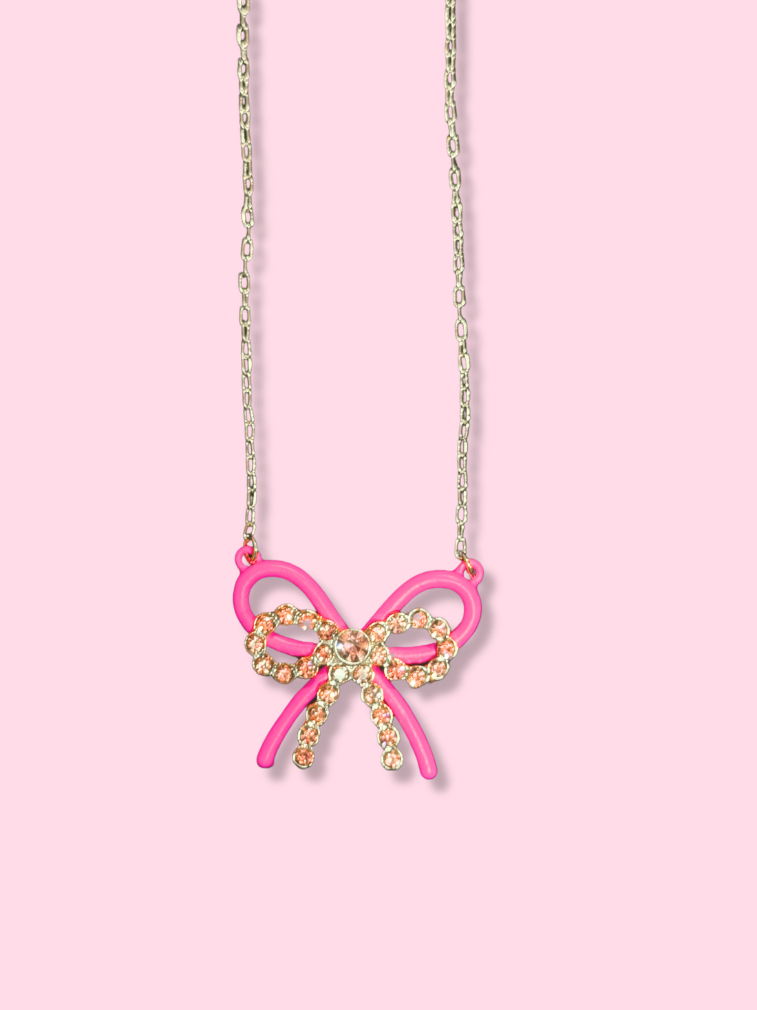 Mila Double Bow Necklace: Pink bow pendant with sparkling crystals on a silver chain.

