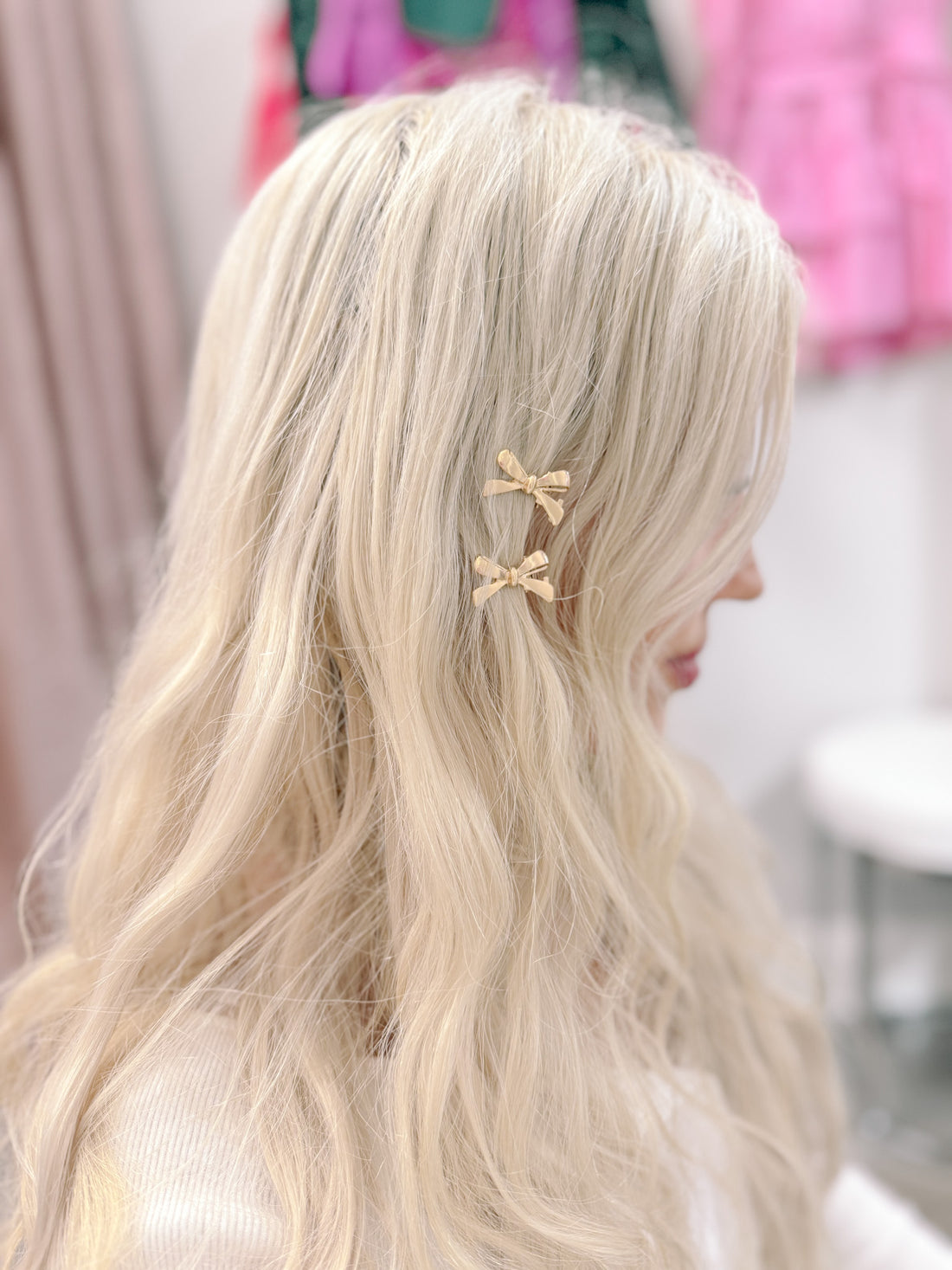 Gold bow hair clips in blonde hair.
