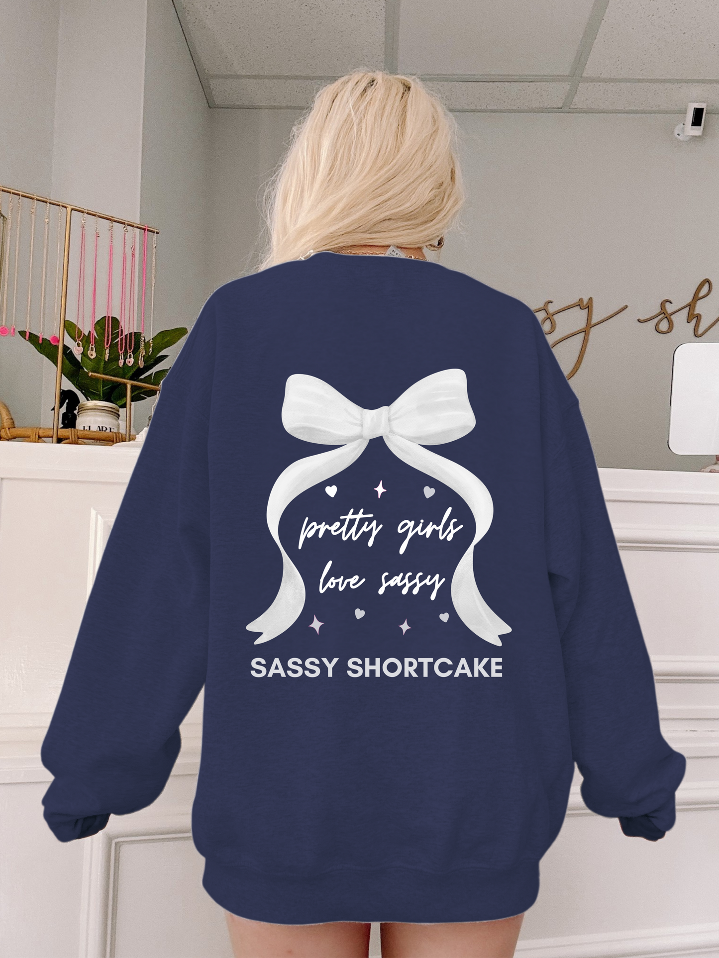 back view of model wearing navy bow crewneck from sassy shortcake