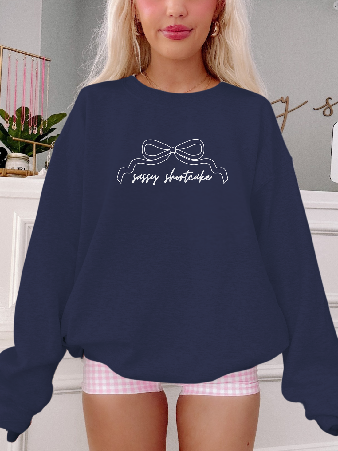 model wearing navy bow crewneck with pink shorts