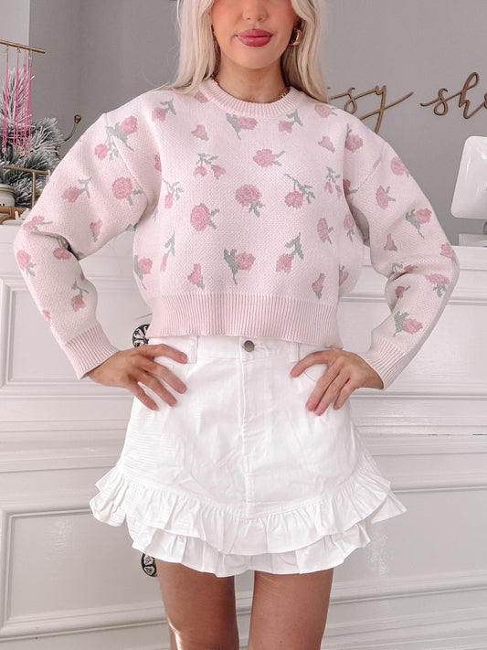 Pink floral knit cropped sweater styled with a white ruffle skirt.