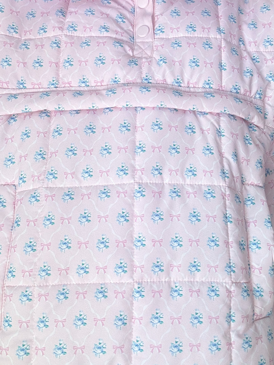 Pink quilted pullover featuring a delicate floral and bow print.

