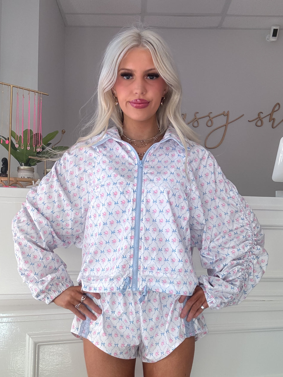 White floral windbreaker and shorts set; light blue accents.
