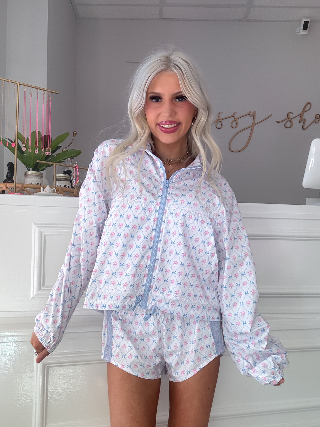 White floral windbreaker and shorts set; pastel pink and blue bow print.
