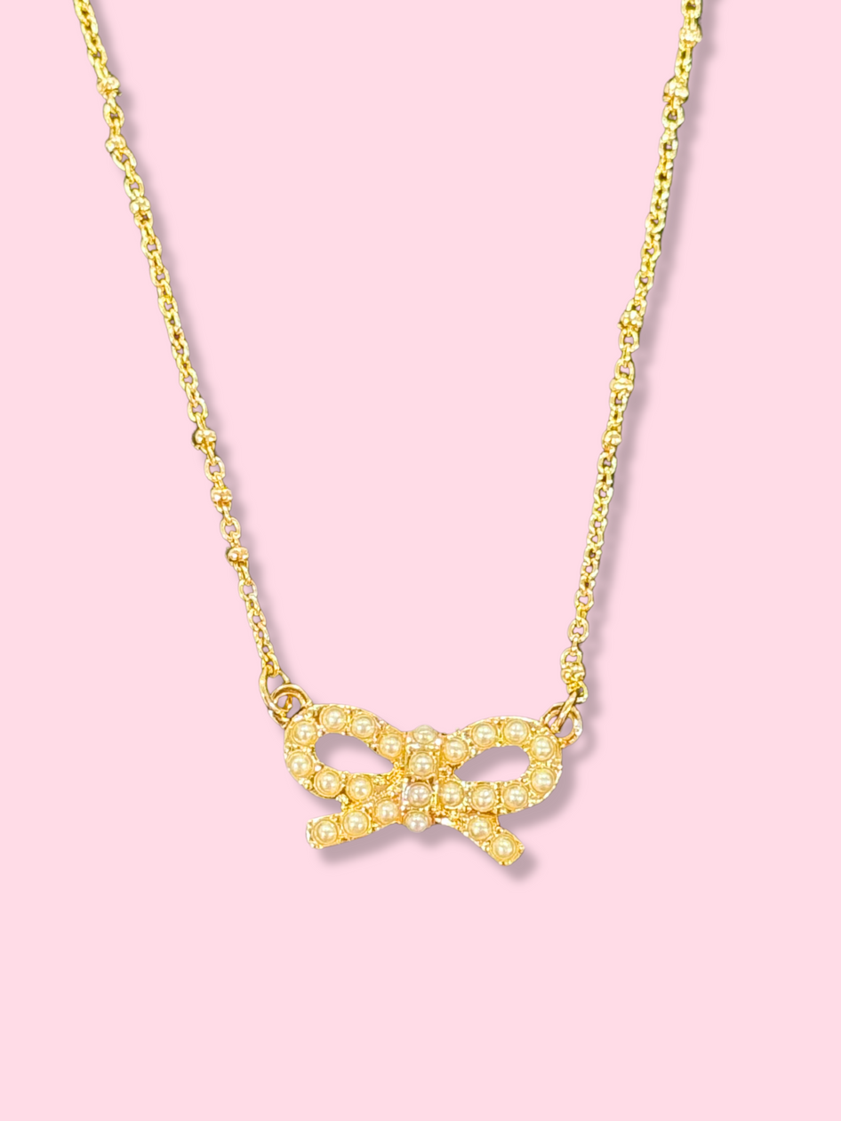 Gold chain necklace with pearl bow pendant
