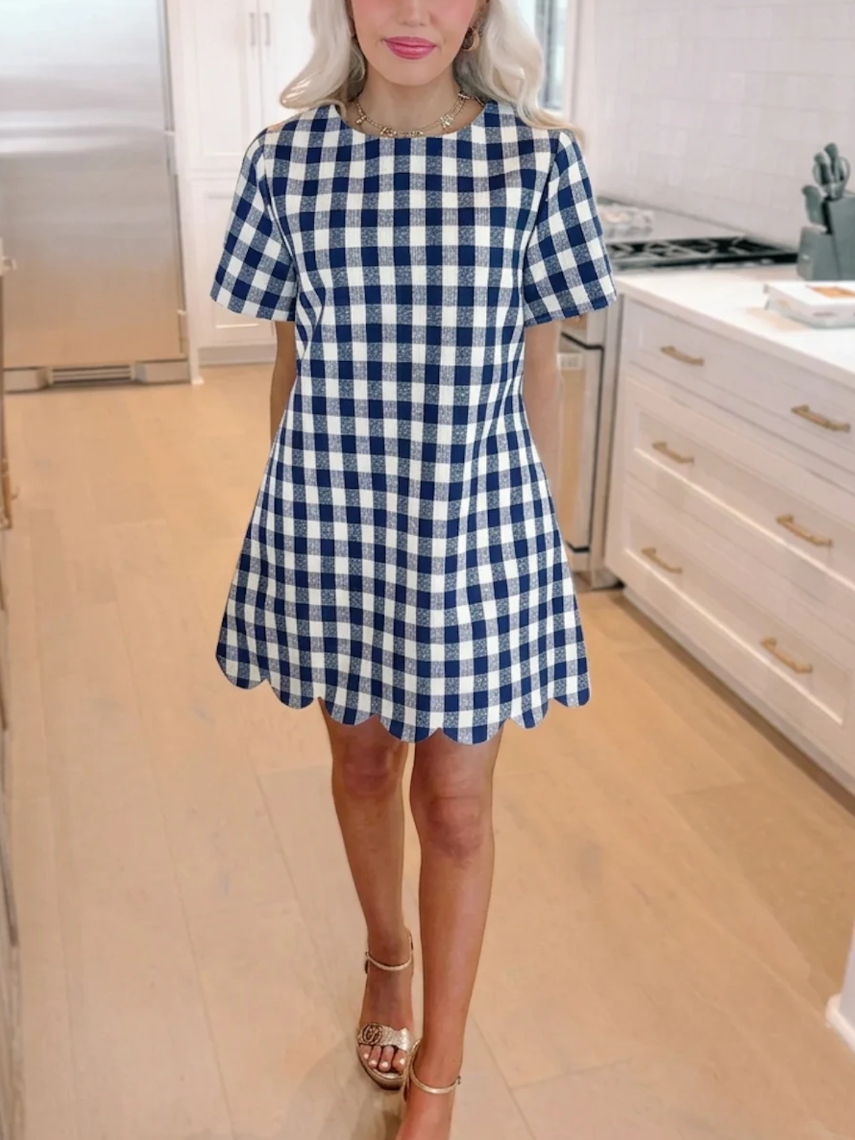 A side-angle close-up of the navy blue Picnic Princess Gingham Dress from Sassy Shortcake showing the preppy checkered fabric and classic shift fit on a blonde model.