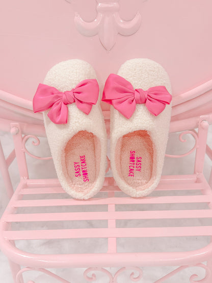 Satin Pink Bow Slippers Sassy Shortcake – pair of fluffy slippers with pink bows displayed on pink bench