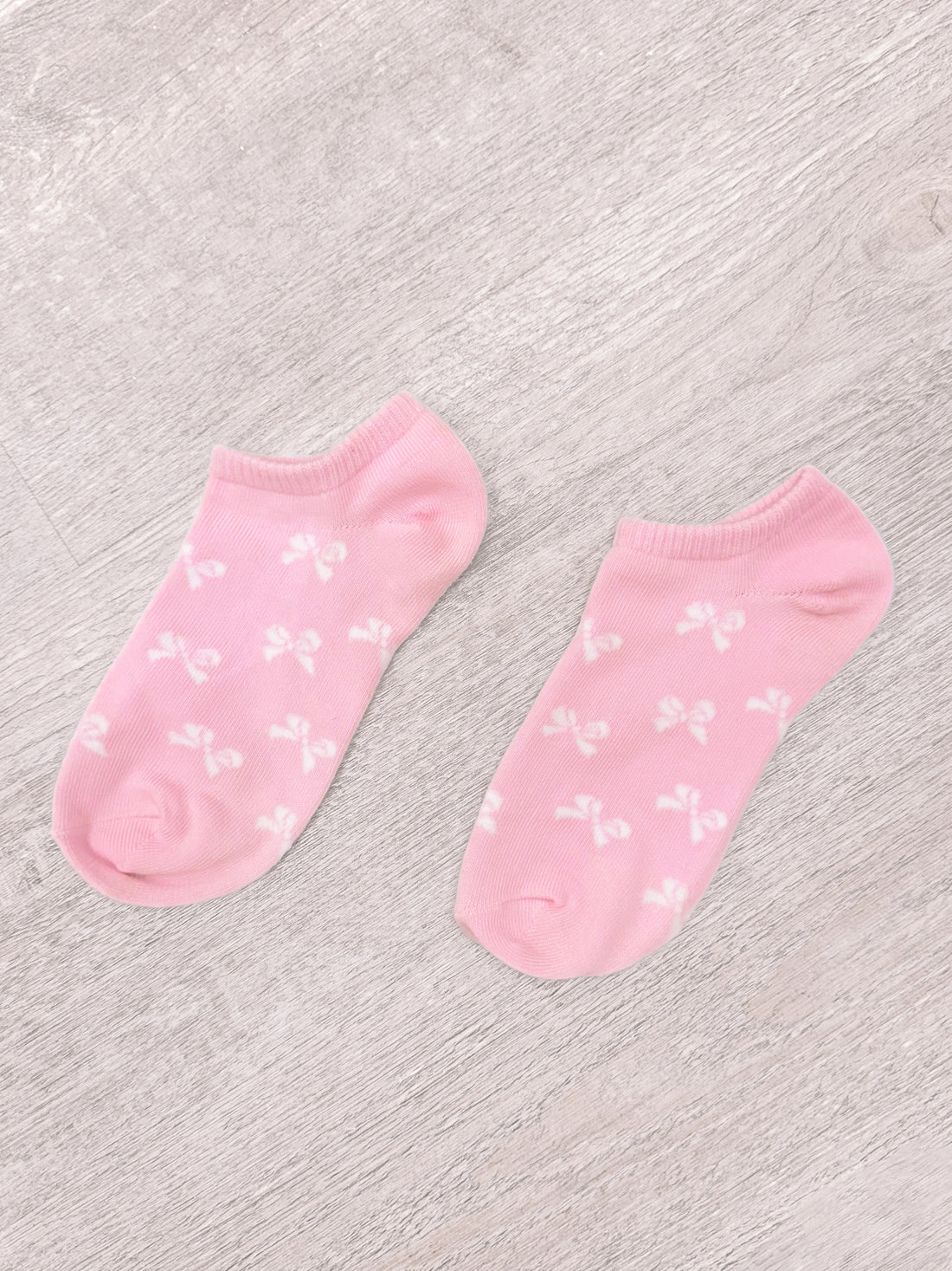Pink bow socks with white bow pattern
