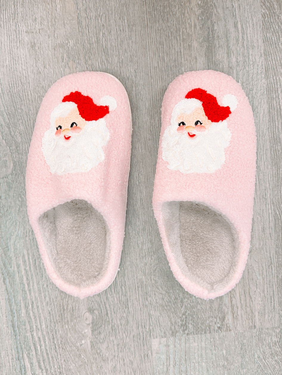 Pink Santa slippers: Cozy plush fleece, Santa face design, perfect for Christmas.
