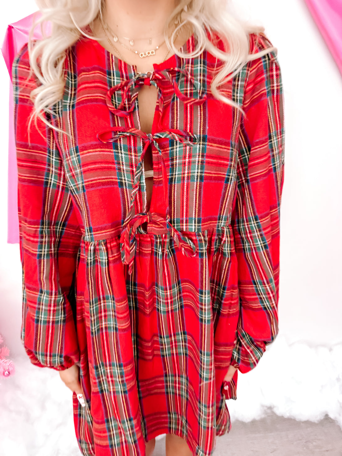 Red plaid mini dress with a tie front and long sleeves.
