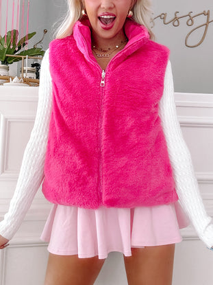 Hot pink plush vest, zip front, worn with white sweater and pink skirt.
